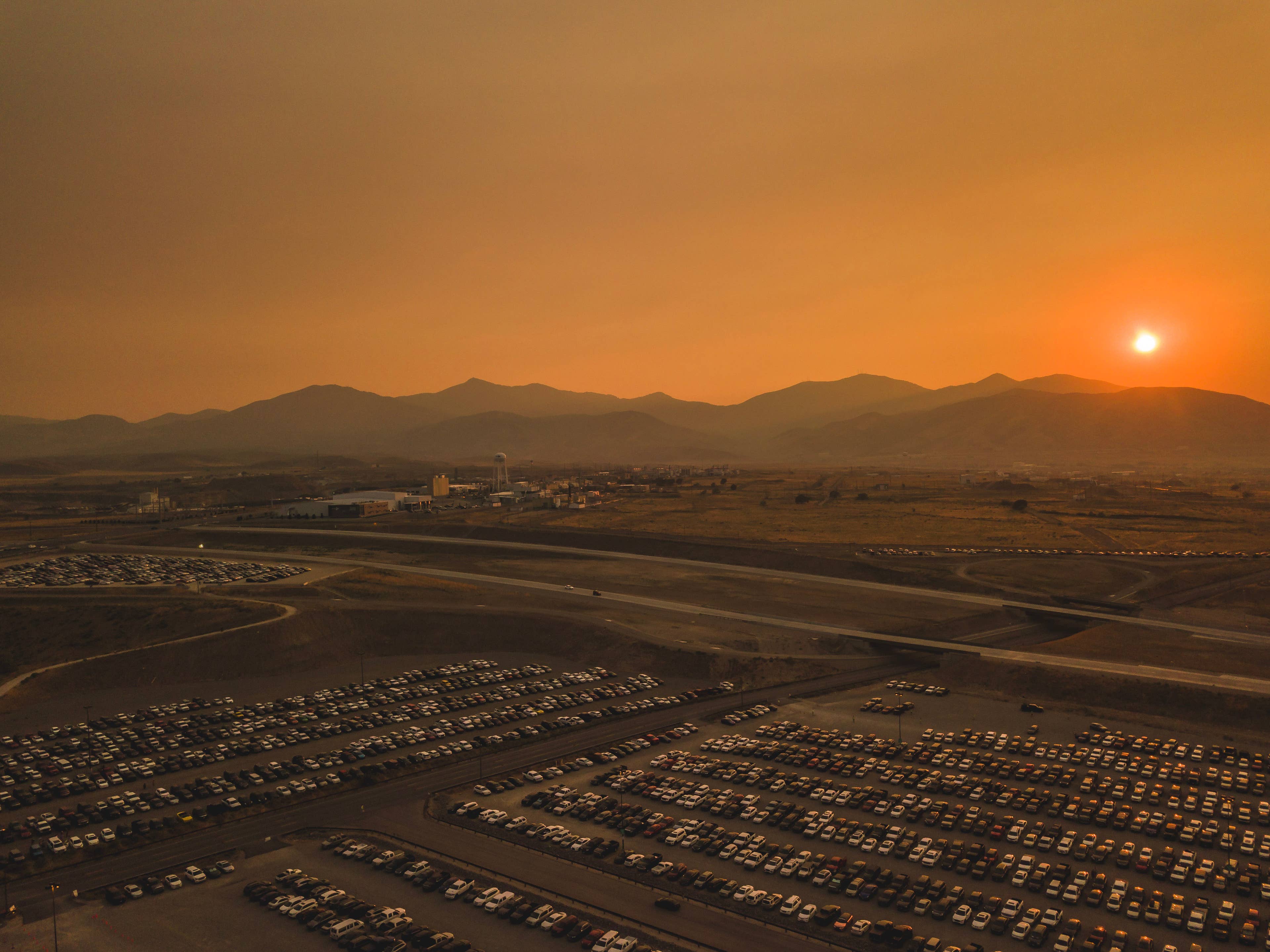 A photo of the parking lot at sunset with mountain range in the background 