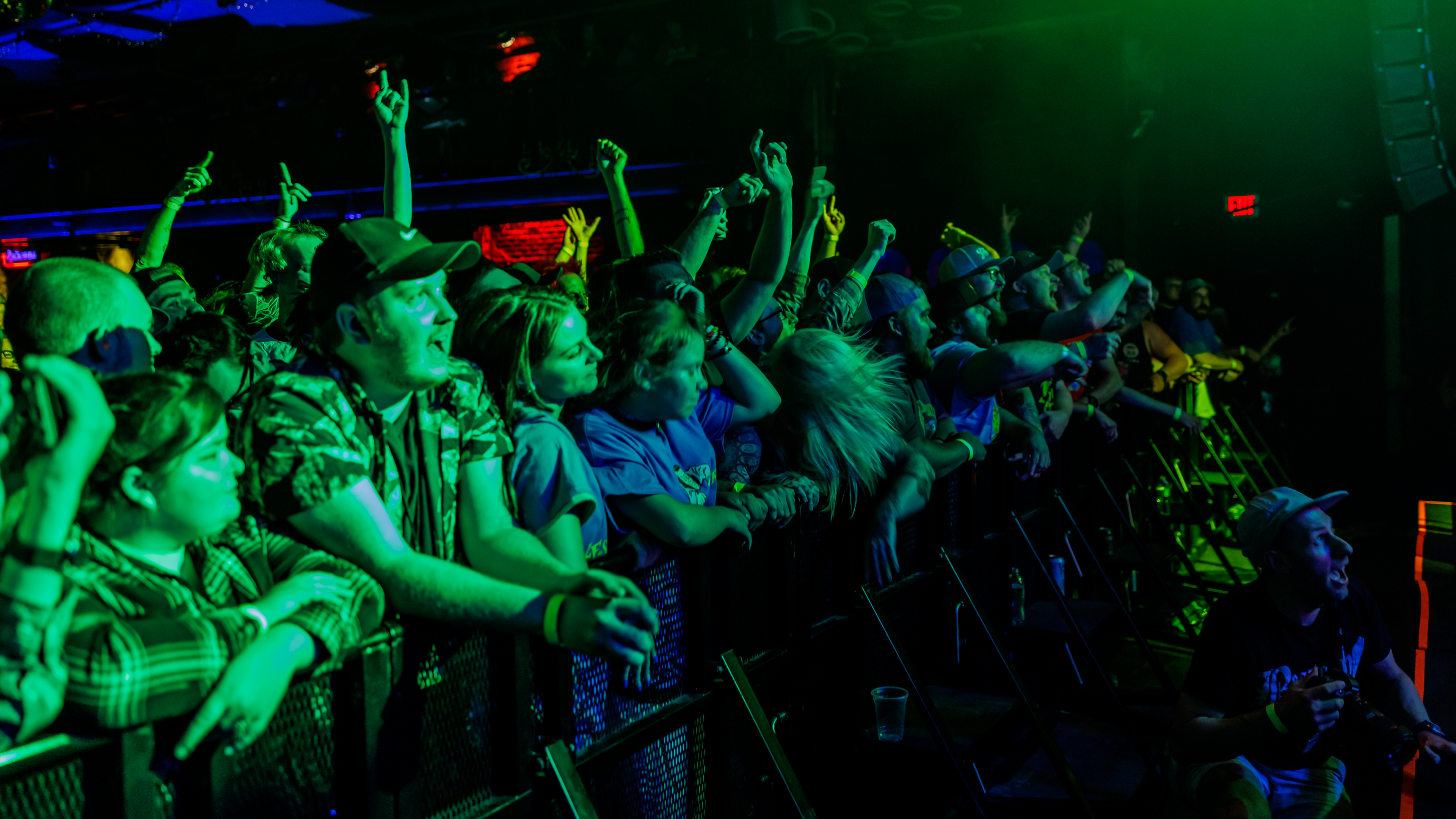 People enjoying a show leaning on the barricade