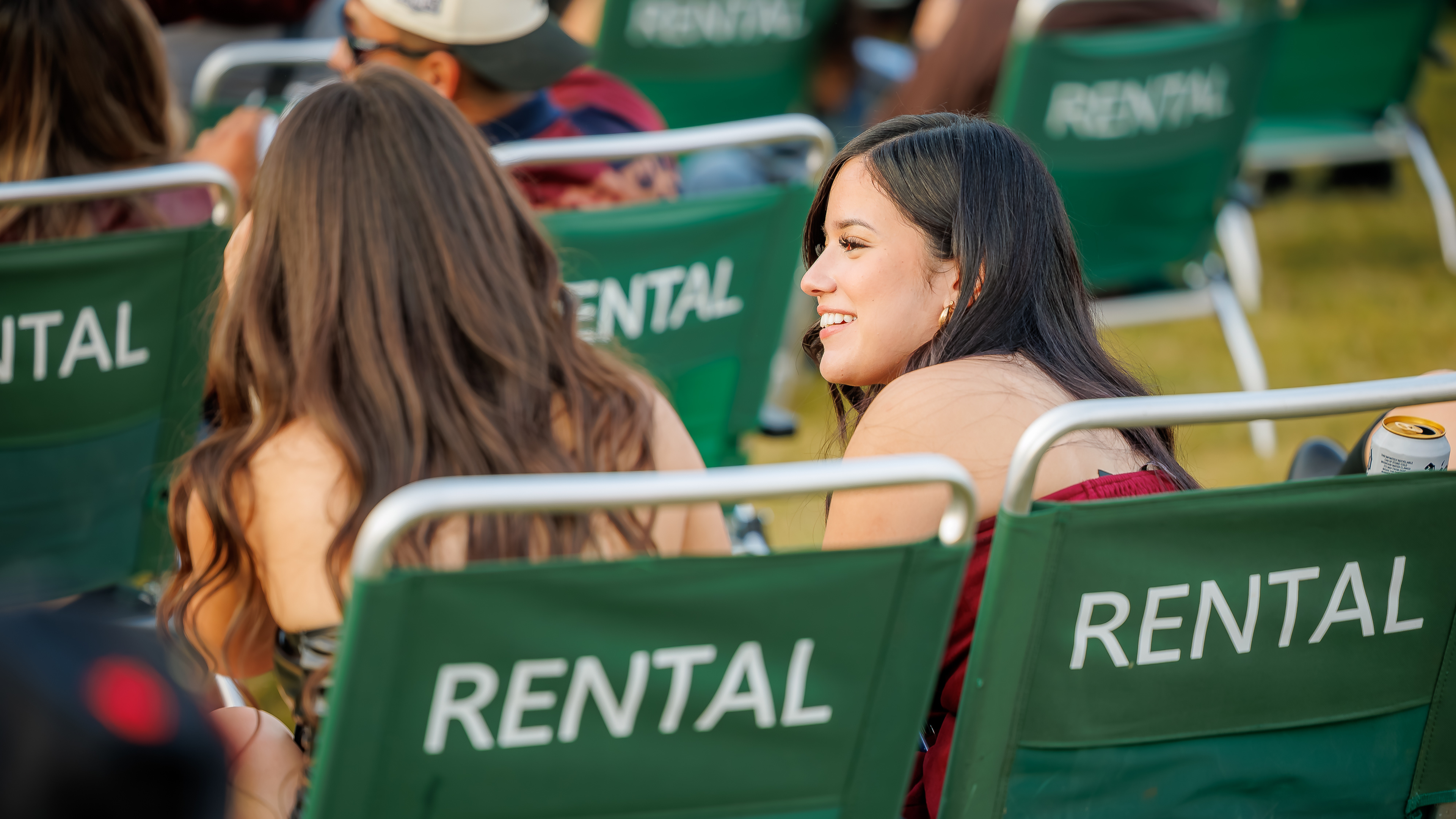 Concertgoers using rental lawn chairs during an outdoor concert