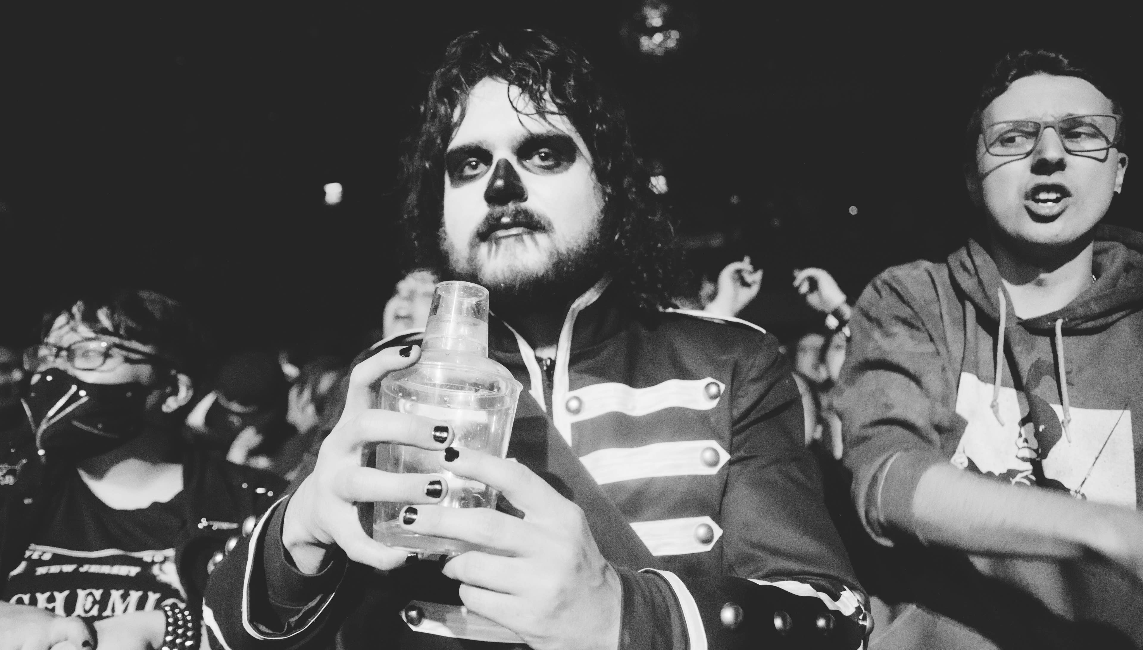 A fan in the crowd at Irving Plaza enjoying a beverage.