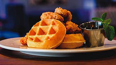 Chicken and Waffles with a cup of syrup