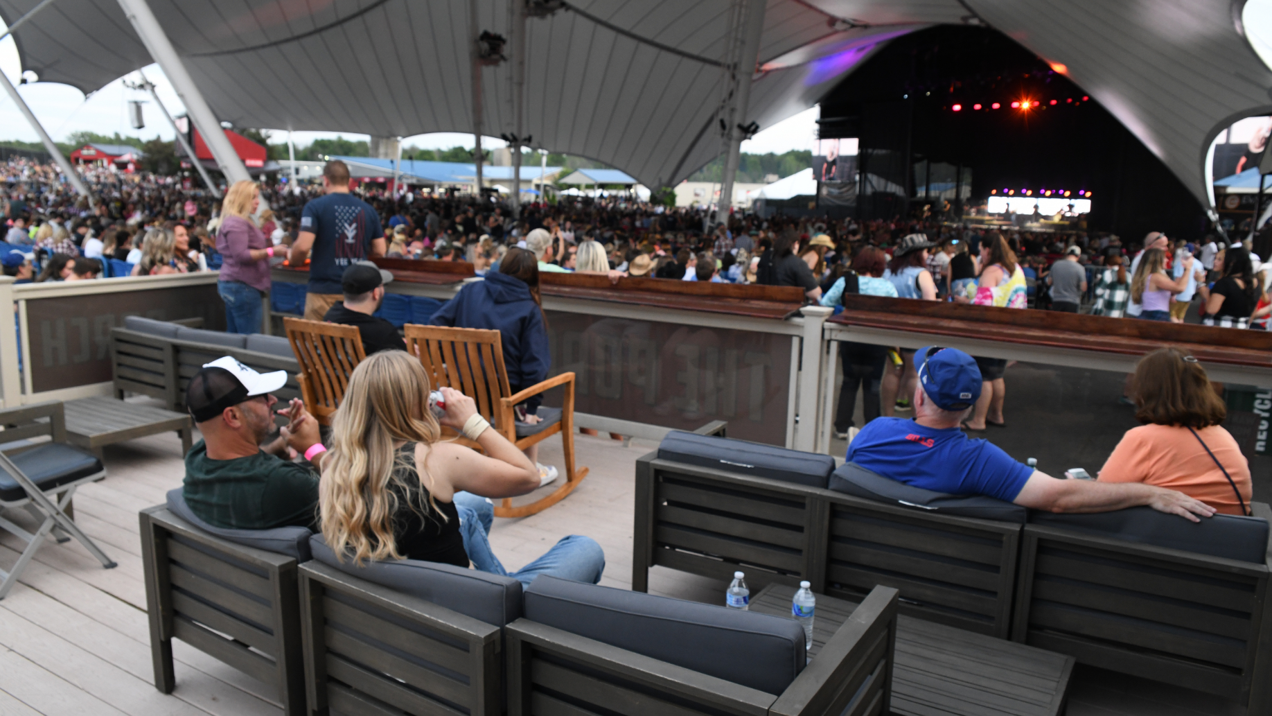 Fans sit on comfortable lounge chairs on the concourse in a secluded area.