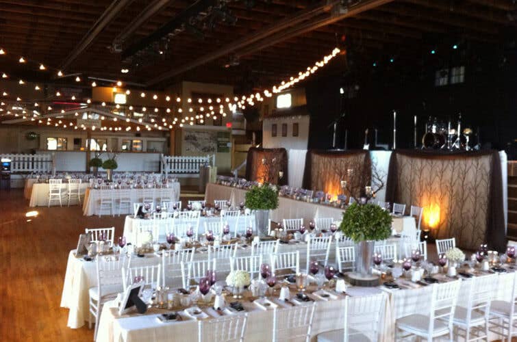 white chairs, and tables with white table cloths set up wedding style with twinkle lights at the kee to bala