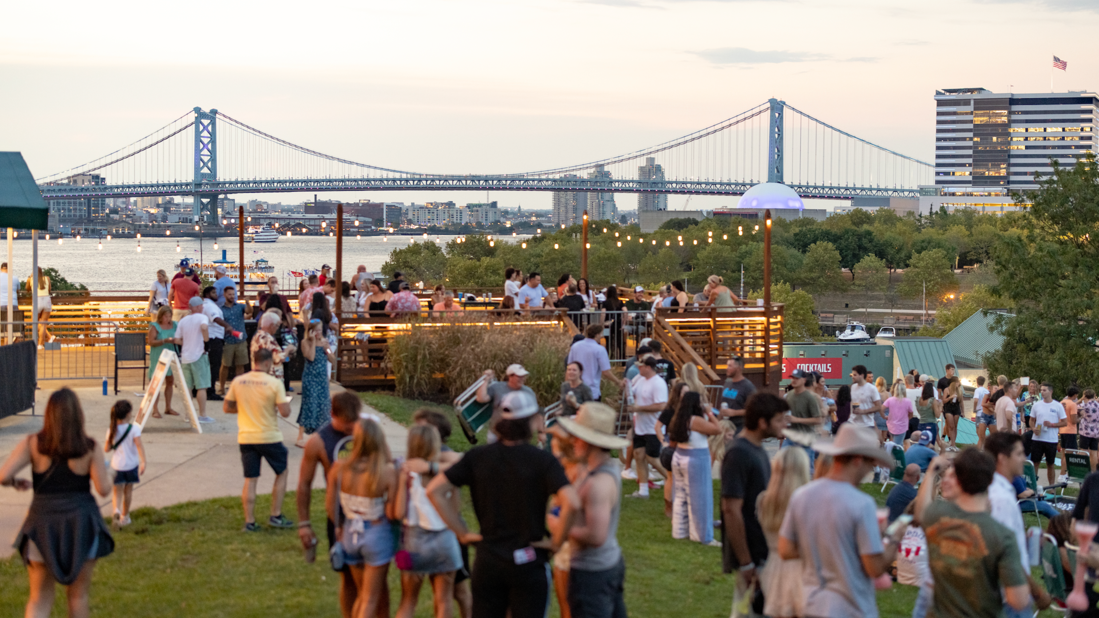 A image of our lawn during a country show with our River Garden deck, Delaware River and Walt Whitman bridge in the background
